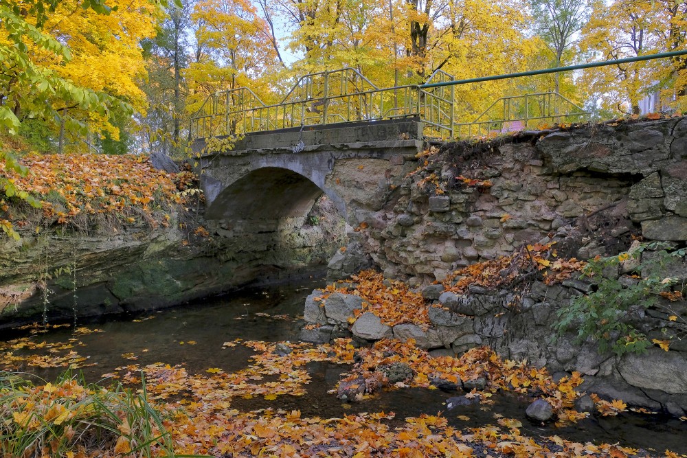 Historic Stone Bridge over River in Golden Autumn Landscape