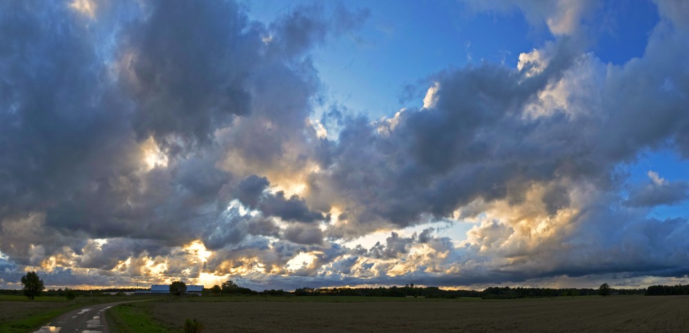 Lauku panorāma ar mākoņainām debesīm