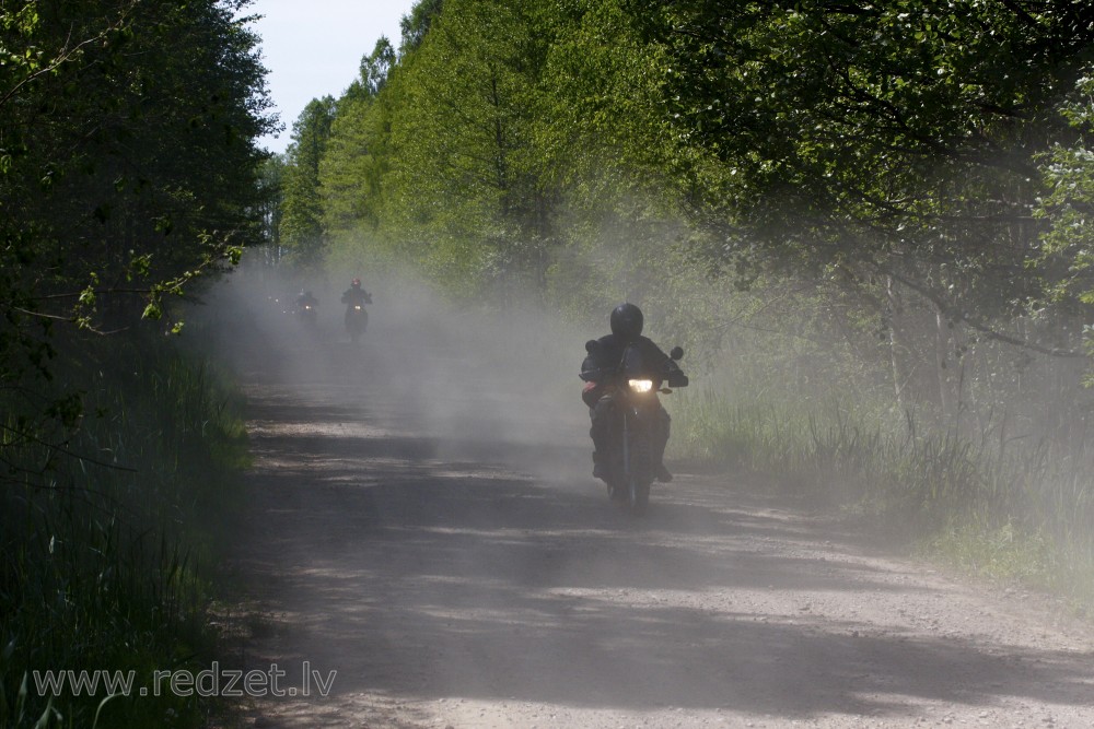 Motorcyclists bike by gravel Road