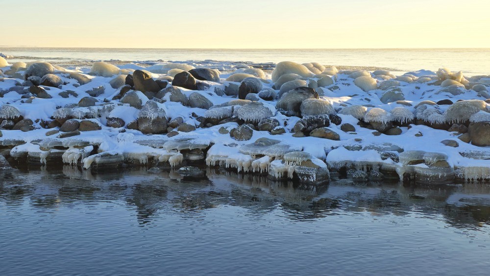 Iced rocks along the Pape canal at winter sunset