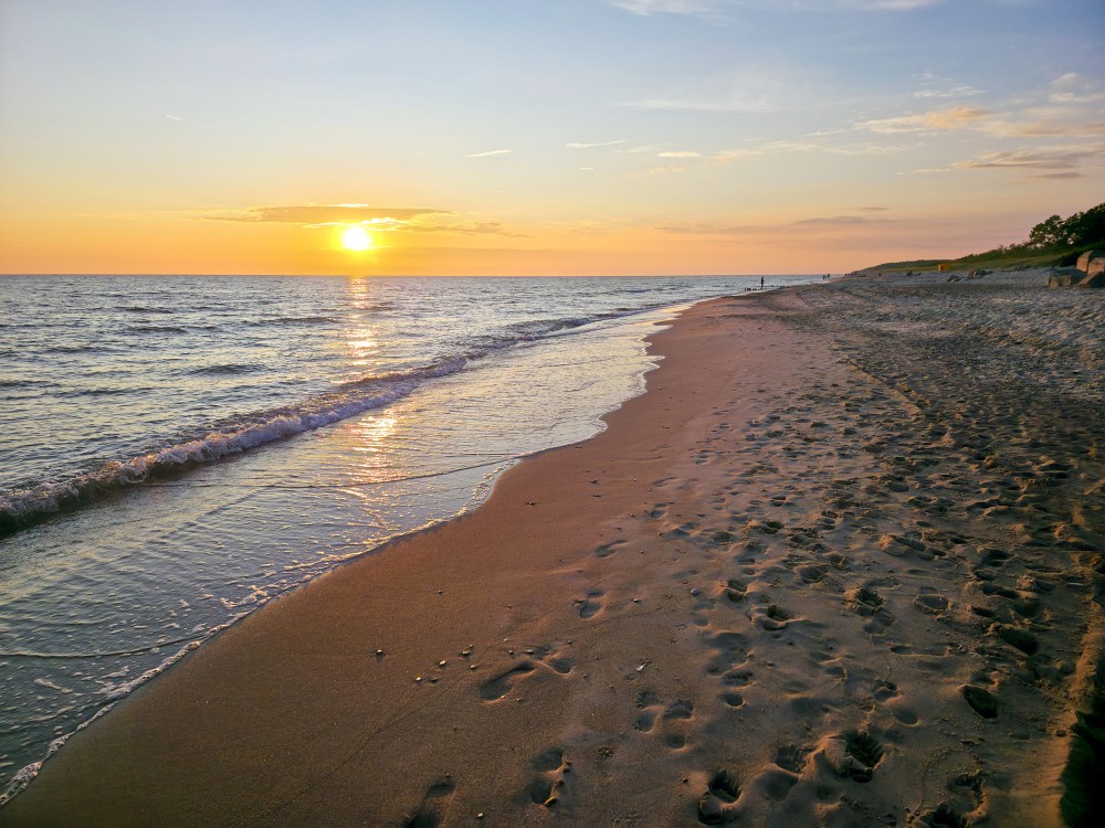 Golden sunset on a sandy beach with footprints