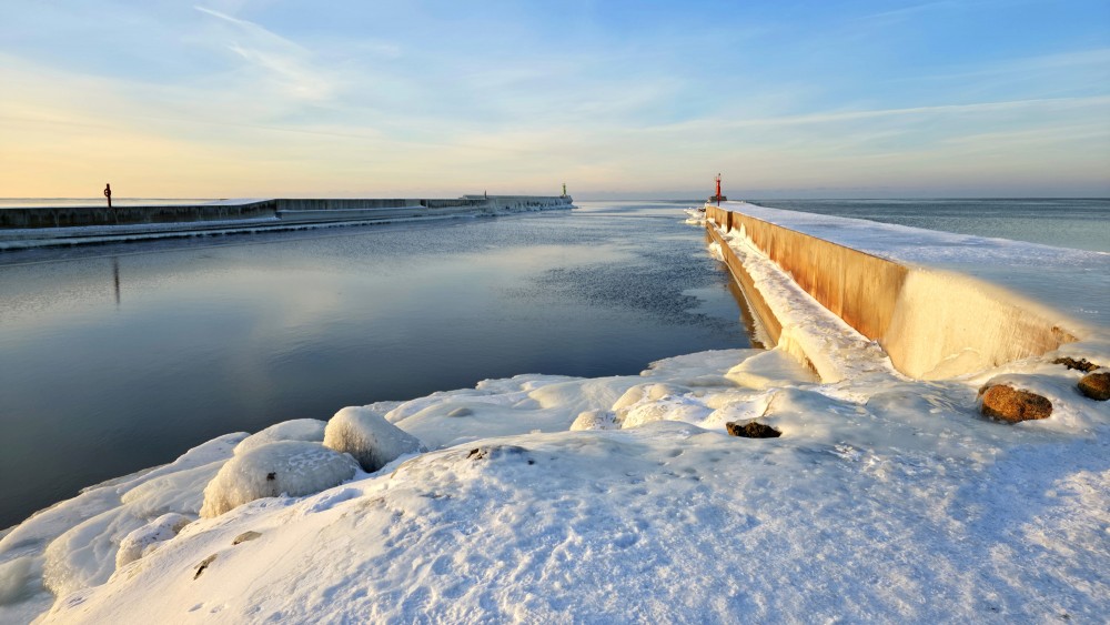 Winter sunset at Pavilosta pier and frozen sea