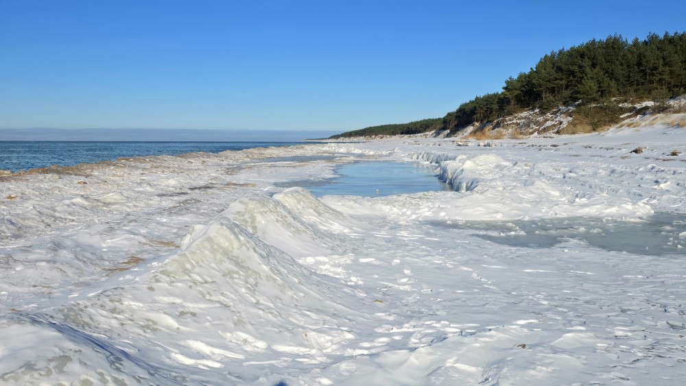 Winter landscape with frozen ice ridges on Ziemupe beach