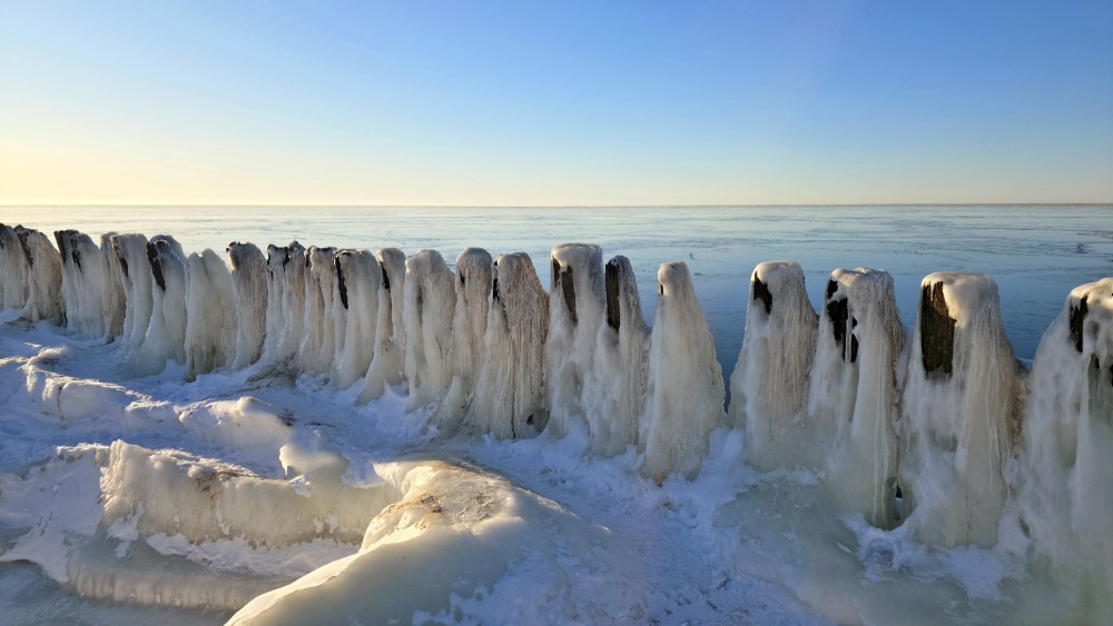 Historic piles of Pape canal against a frozen sea