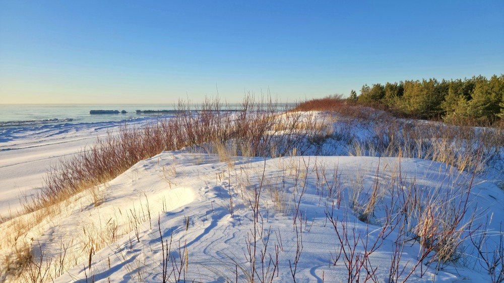 View from a snowy dune towards the Baltic Sea at Pape beach