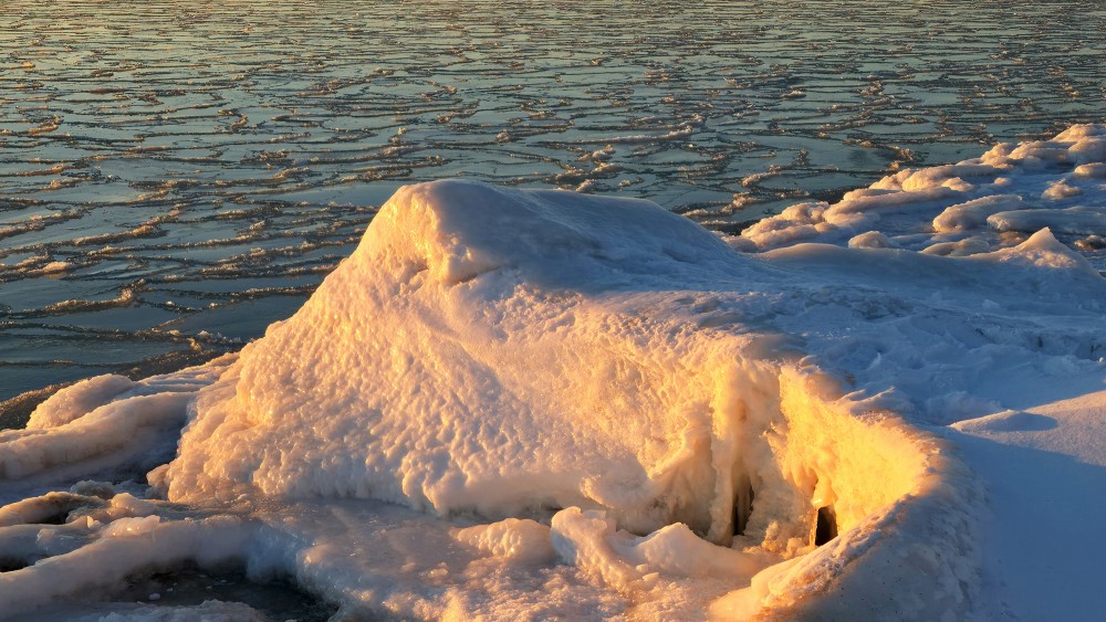 Golden sunset light on ice formations by the frozen sea