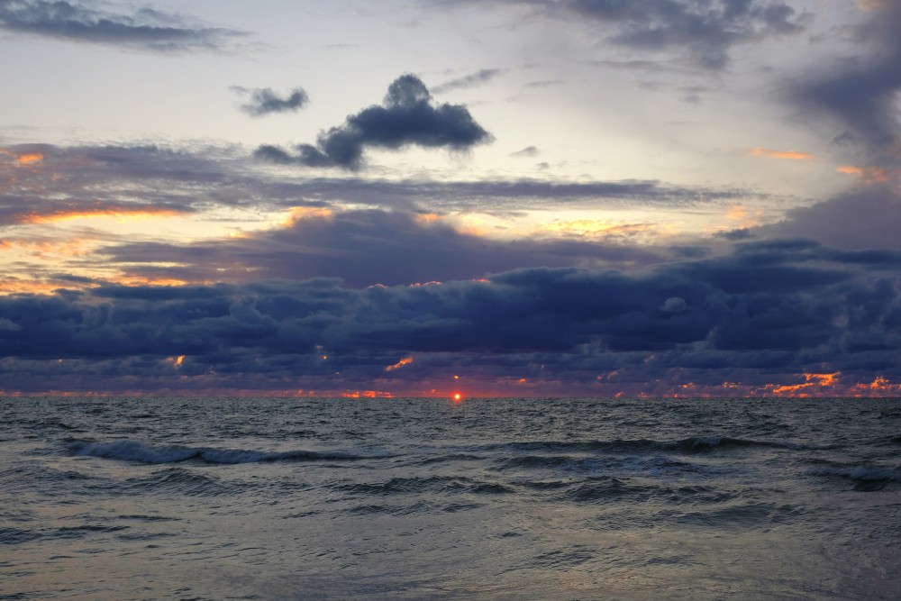 Jūras saulrieta ainava, mākoņainas debesis