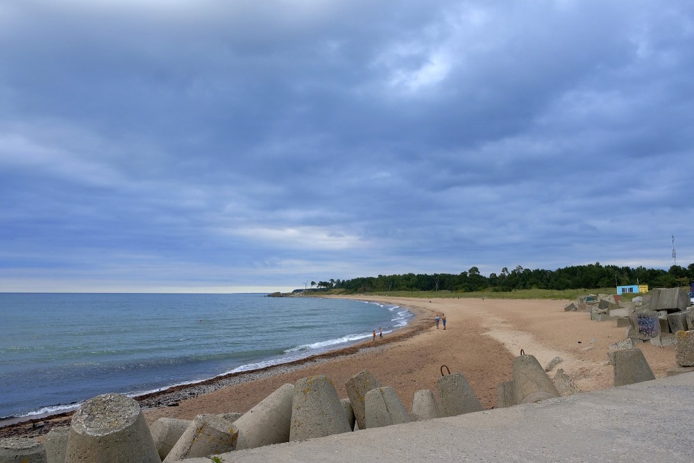 Pludmale pie Liepājas Ziemeļu mola zem pelēkām mākoņainām debesīm