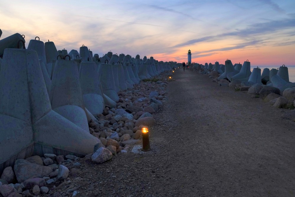 Sunset at Ventspils Southern Pier with lighthouse and lit pathway