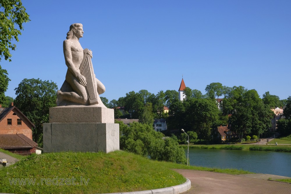 Piemineklis „Koklētājs” uz Talsu fona